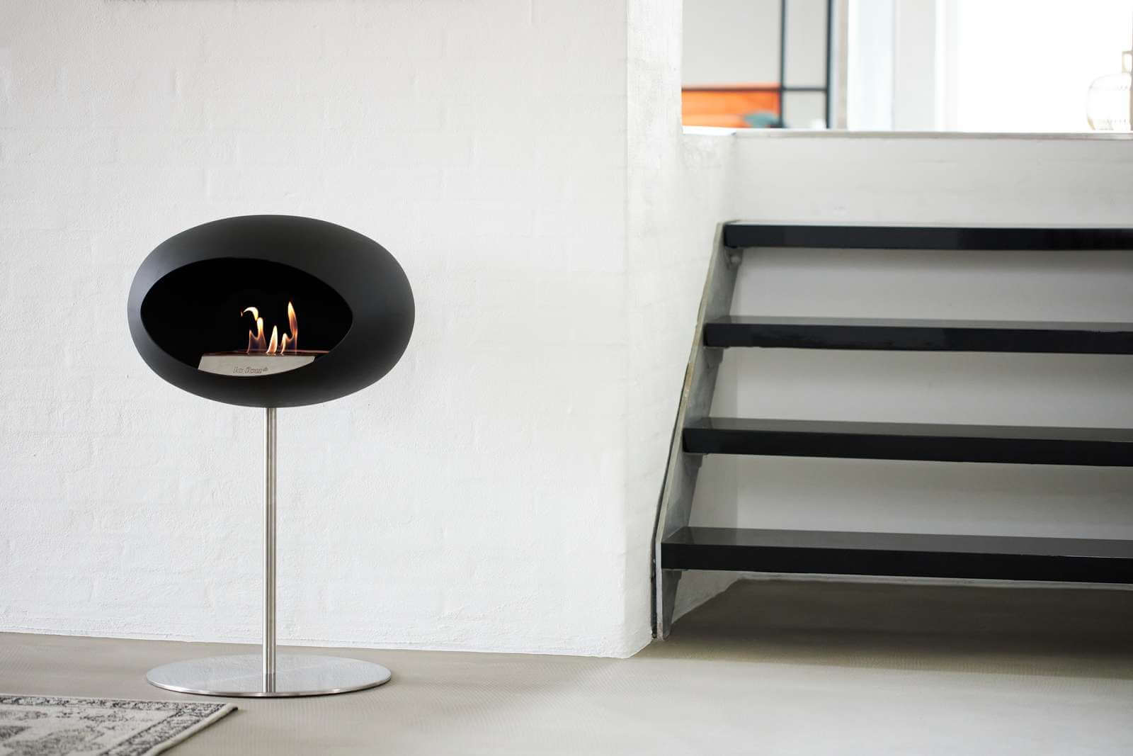 Freestanding Le Feu Dome bioethanol fireplace in black, positioned in a modern indoor setting.