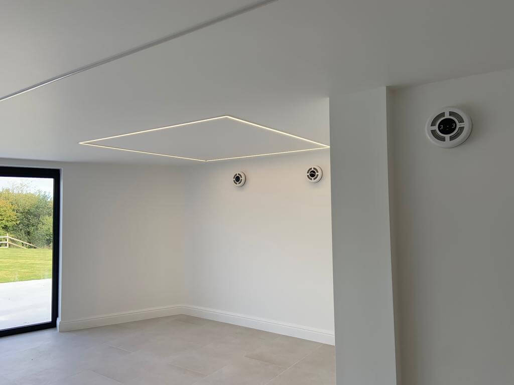 Modern interior featuring a heat recovery ventilation system with circular vents for energy-efficient air exchange.
