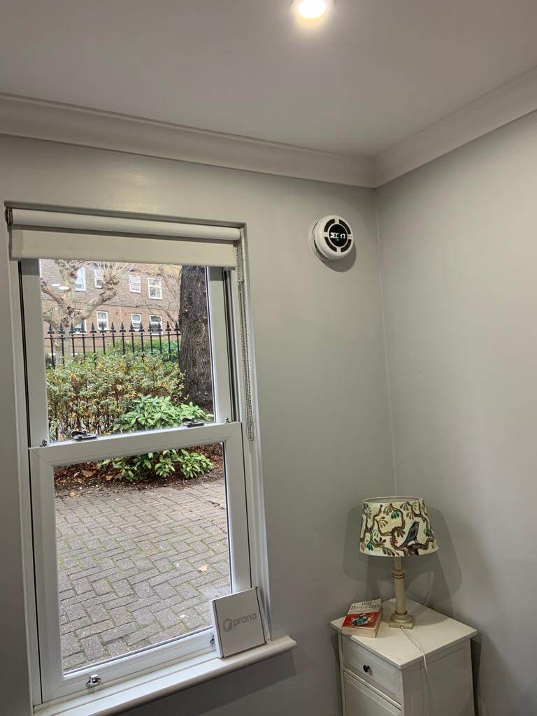 Interior view showcasing the PRANA 160 STANDARD MINI heat recovery ventilator installed near a window.