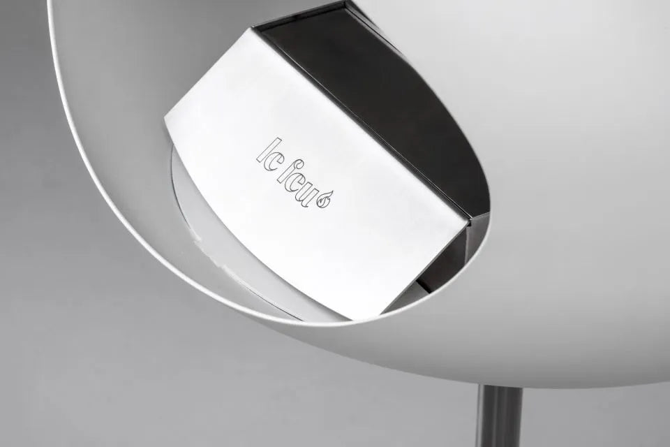 Close-up of Le Feu Dome bioethanol fireplace showcasing sleek design and branding in stylish white finish.