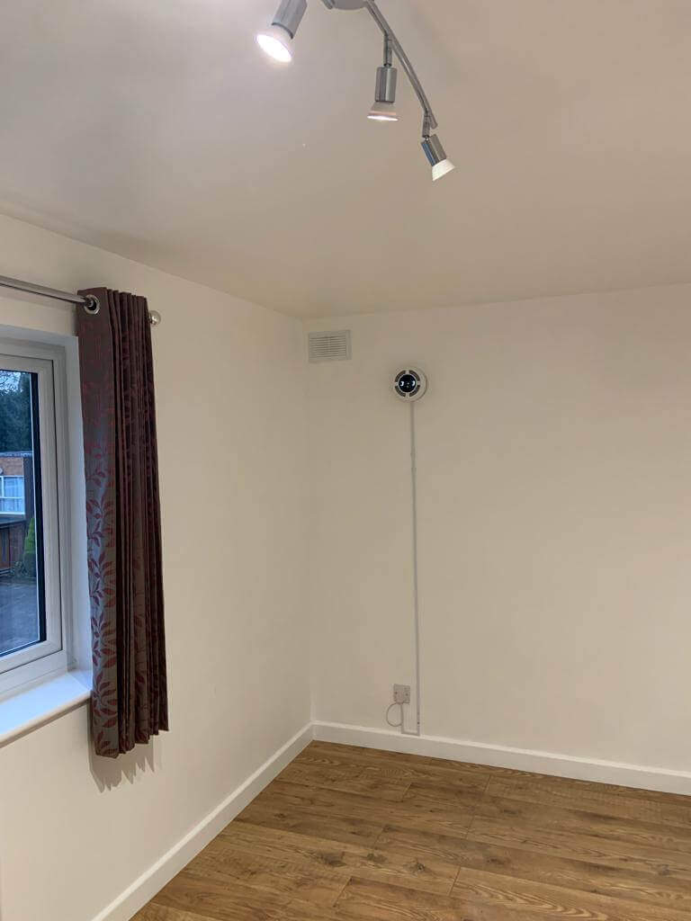 Interior view showcasing a heat recovery ventilation system installed in a modern room with wood flooring.