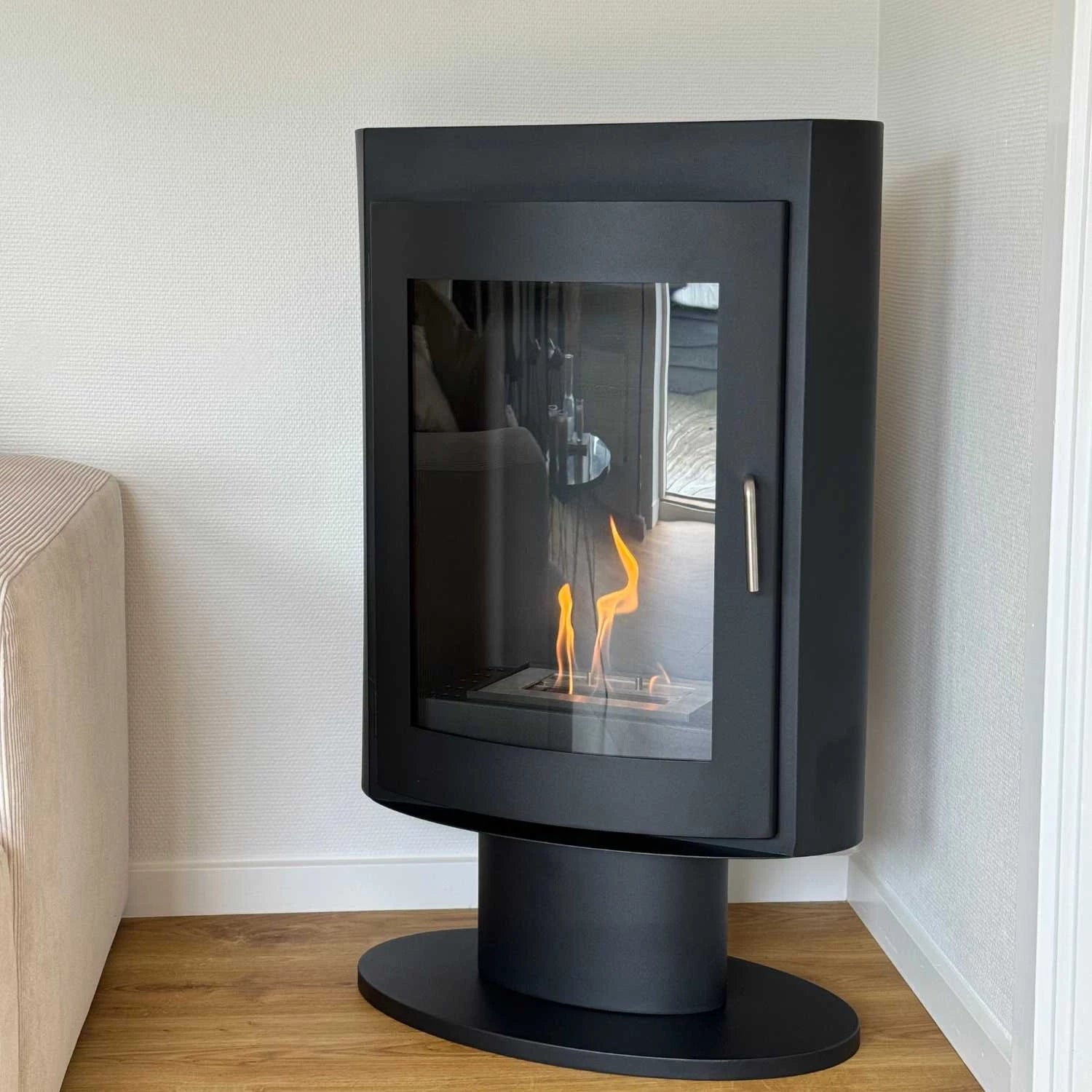 Trenton freestanding bioethanol stove in black steel, showcasing the flame through a glass front, perfect for modern decor.