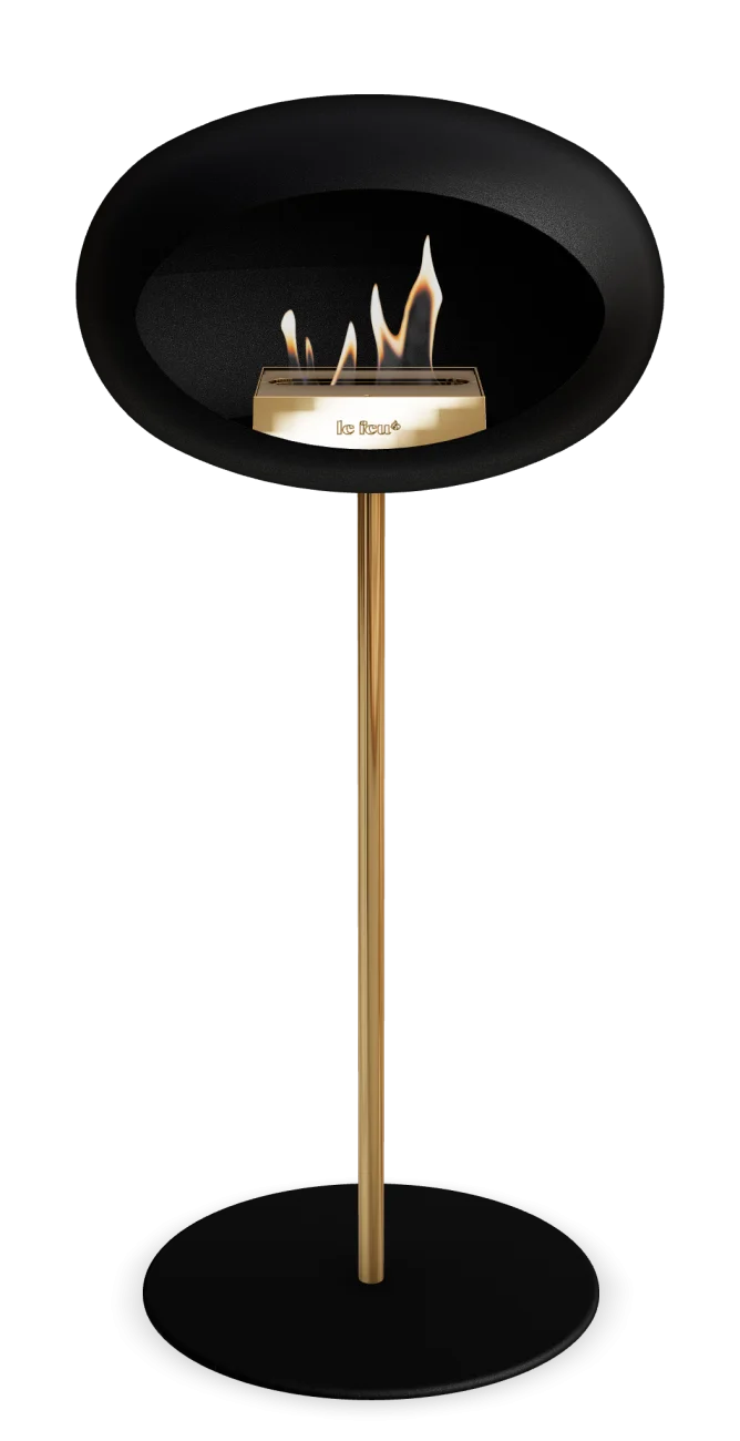 Freestanding black bioethanol fireplace Le Feu Dome with gold accents, perfect for indoor and outdoor living.
