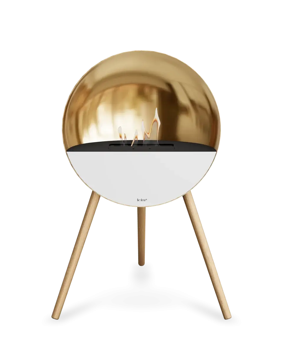 Freestanding rose gold bioethanol fireplace Le Feu Eye with flames, perfect for cozy ambiance in any room.