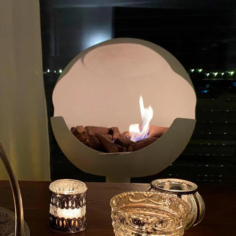 Modern bio fireplace featuring decorative ceramic logs with a flame, creating a cozy atmosphere.