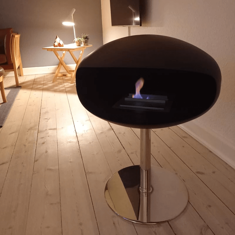 Cocoon Pedestal matte black bioethanol fireplace on steel pedestal in modern living space, radiating elegance and warmth.