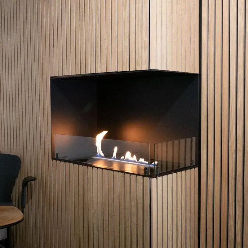 Elegant built-in bioethanol fireplace with glass protection, showcasing flames in a modern wooden interior.