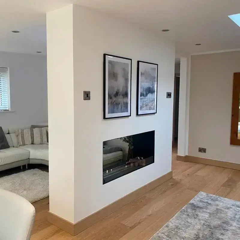 Modern living room featuring a bioethanol fireplace insert, framed artwork, and sleek design elements.
