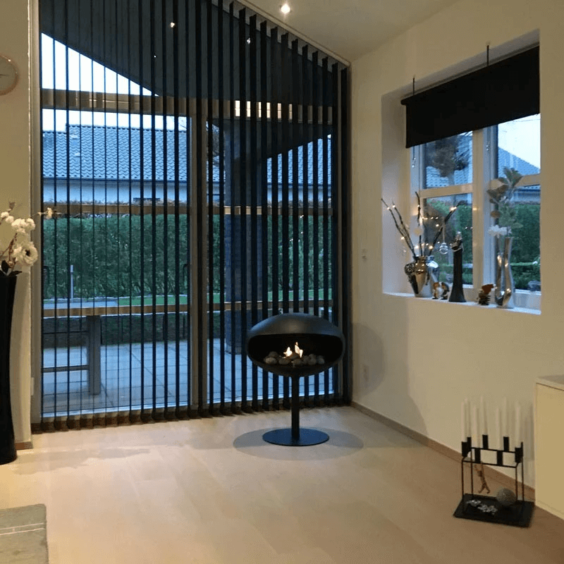 Modern interior featuring Cocoon Pedestal bioethanol fireplace in black, providing stylish warmth and ambiance.