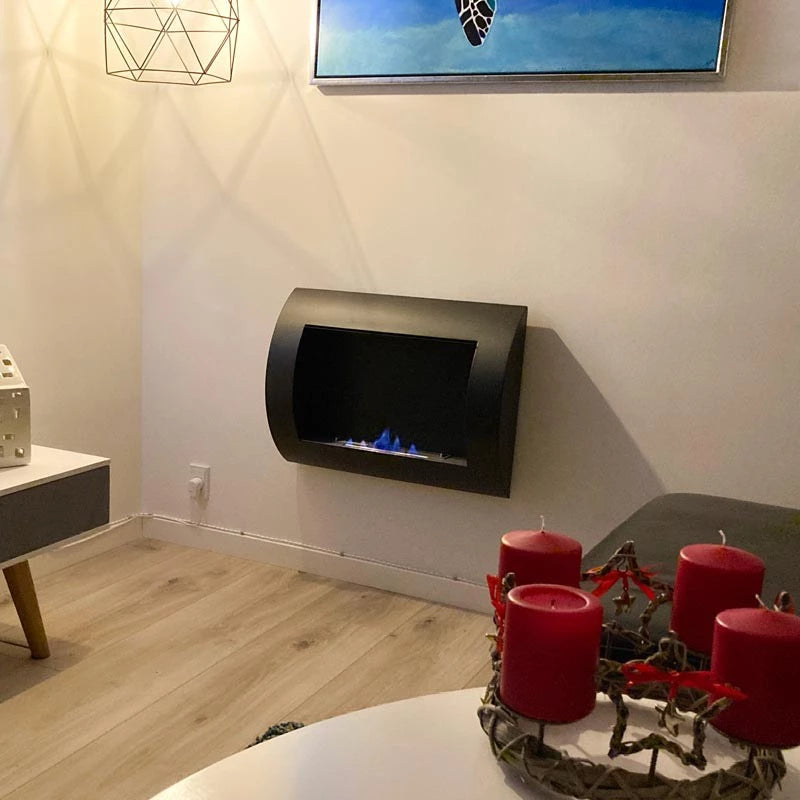 Wall-mounted black bio fireplace with blue flames, modern design enhancing contemporary interior decor.