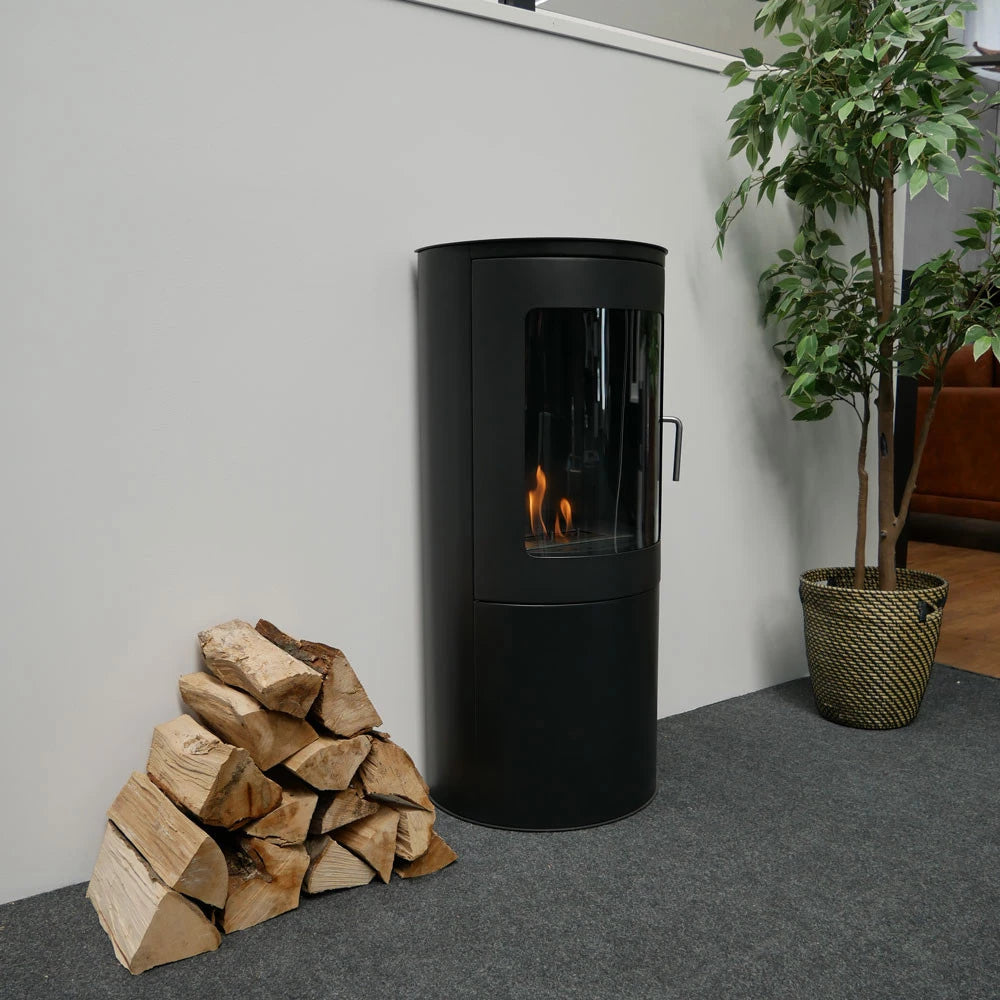 Richmond Bioethanol fireplace stove with flat back, freestanding design, next to a stack of firewood.