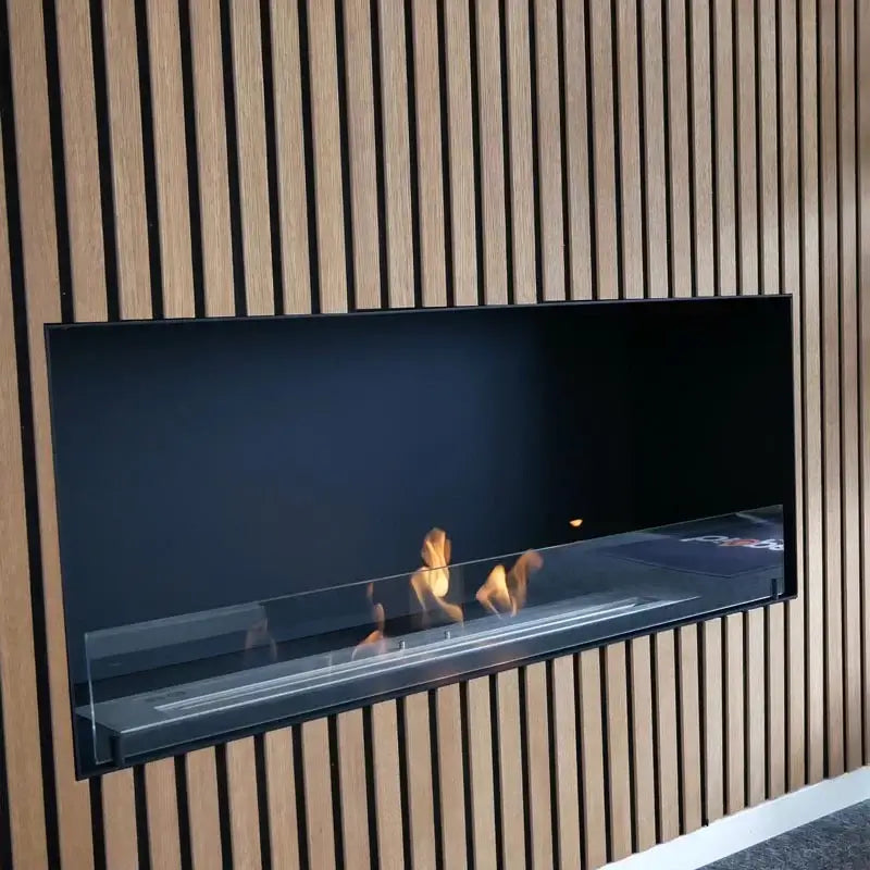 Sleek built-in bioethanol fireplace with glass panel, creating a cozy modern atmosphere against wooden wall.