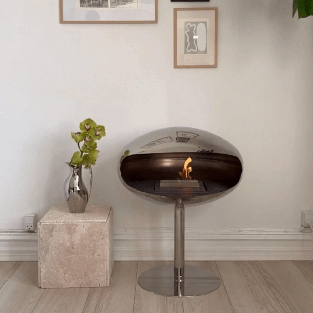 Elegant Cocoon Pedestal bioethanol fireplace in polished steel, enhancing modern interior decor.
