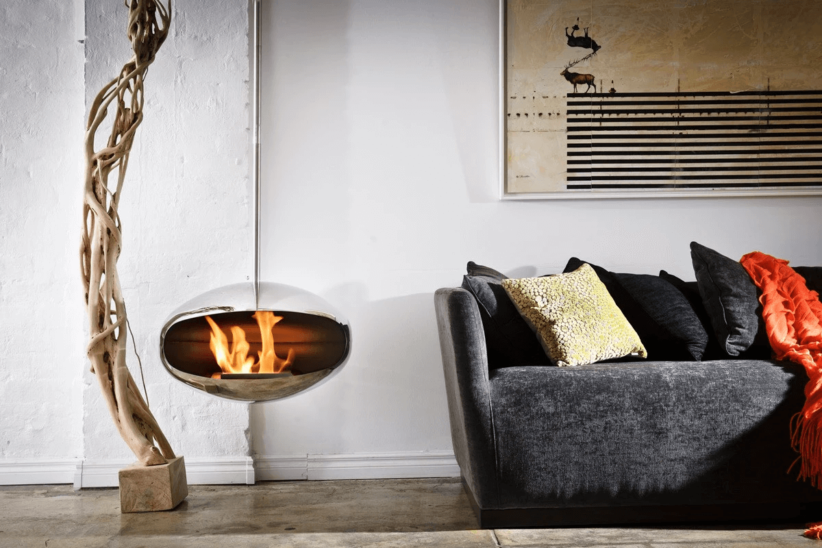 Cocoon Aeris bioethanol fireplace suspended near a modern sofa and artistic decor in a stylish interior.