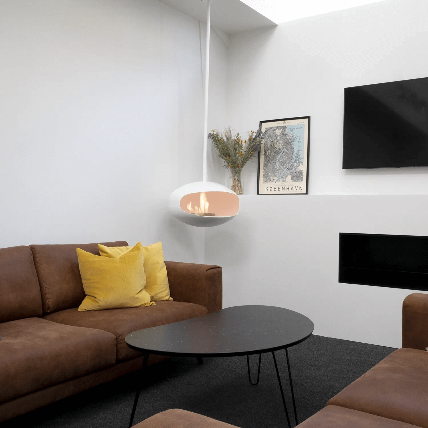Cocoon Aeris ceiling-hung bioethanol fireplace in matte white, enhancing a stylish modern living room decor.