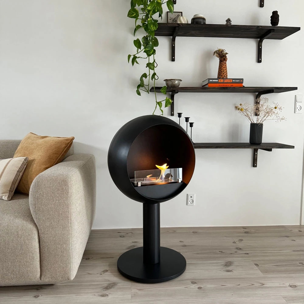 Edmonton freestanding bioethanol fireplace in modern living room, featuring a black round design showcasing flames.