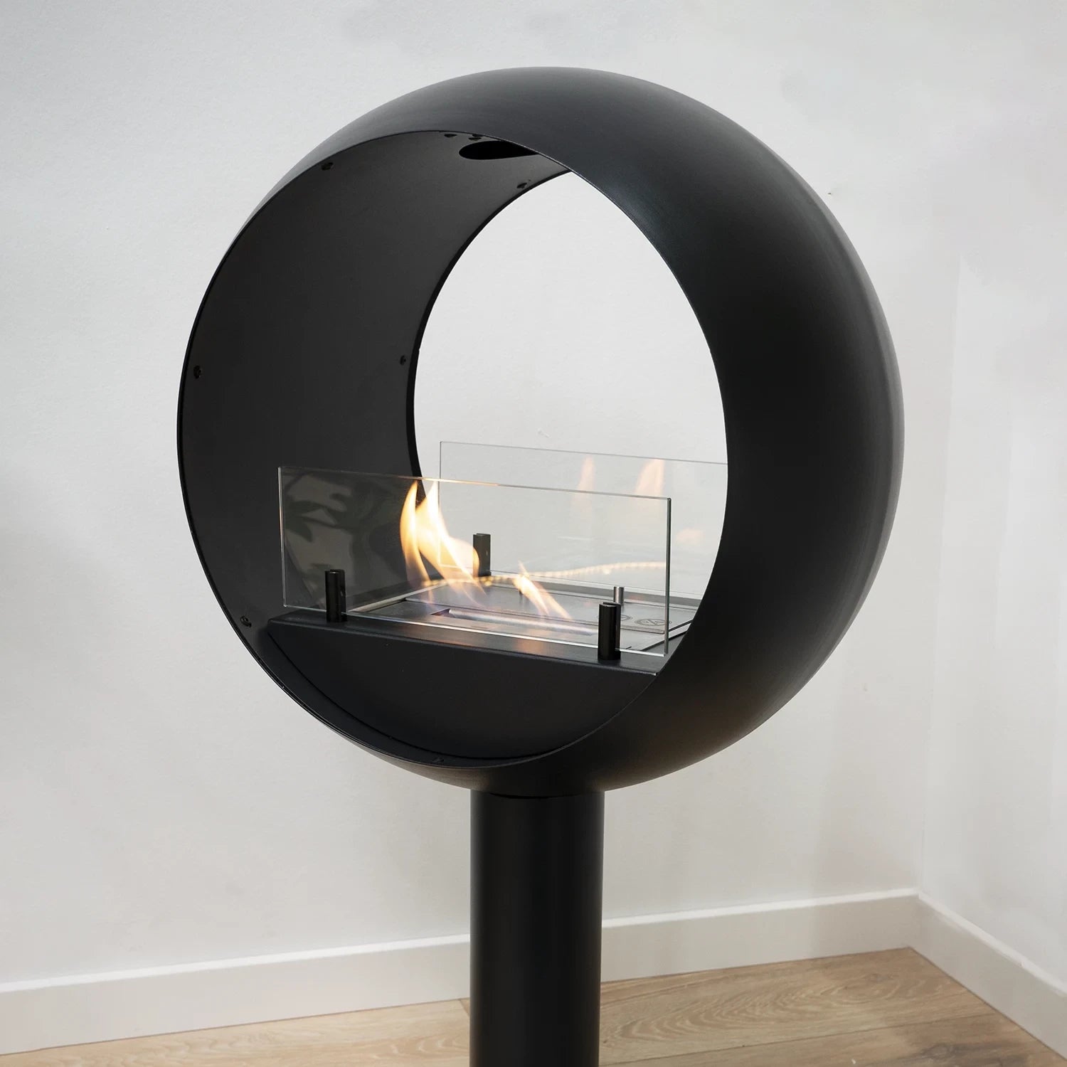Edmonton 2-sided freestanding bio fireplace featuring a round black design with visible flames from both sides.