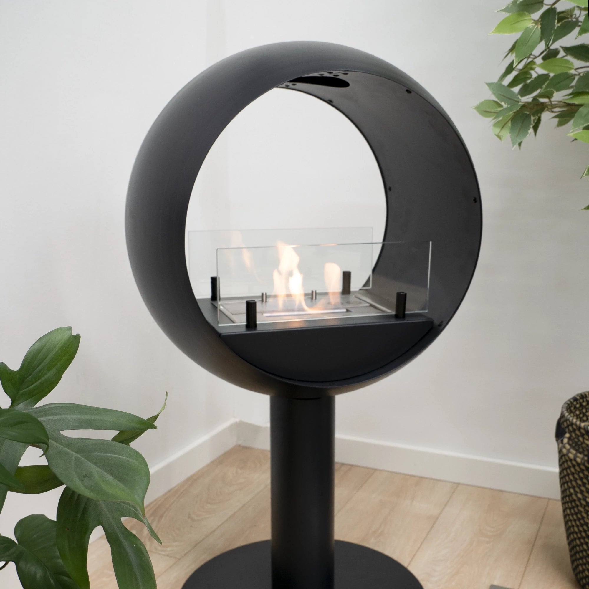 Edmonton 2-sided freestanding bio fireplace with black round frame and visible flames, perfect for indoor decor.