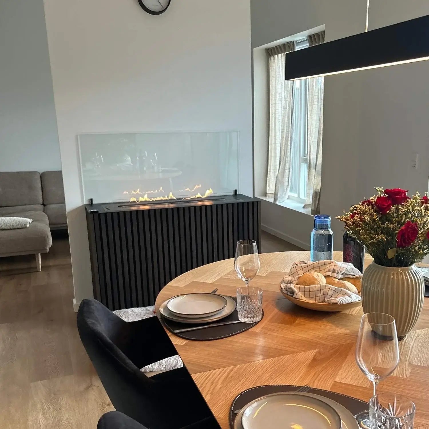 Modern dining area featuring a bioethanol fireplace with a sleek glass front and stylish decor.