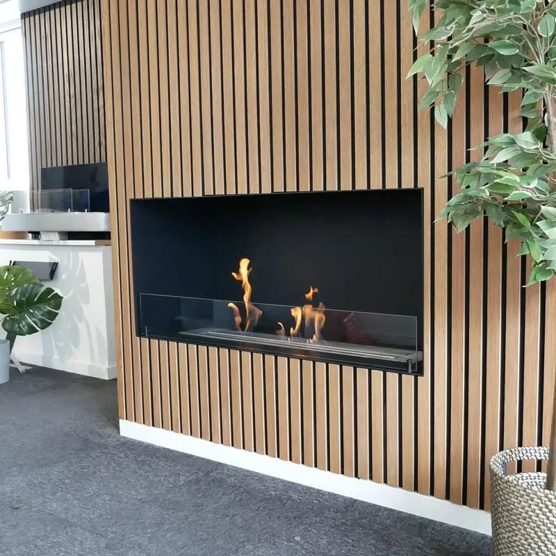 Stylish bioethanol fireplace Foco One 1200 built into modern wall, showcasing flames and sleek design.