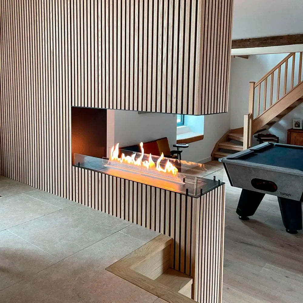 Modern bioethanol fireplace insert with flames, featured in a stylish wood-paneled room setting.