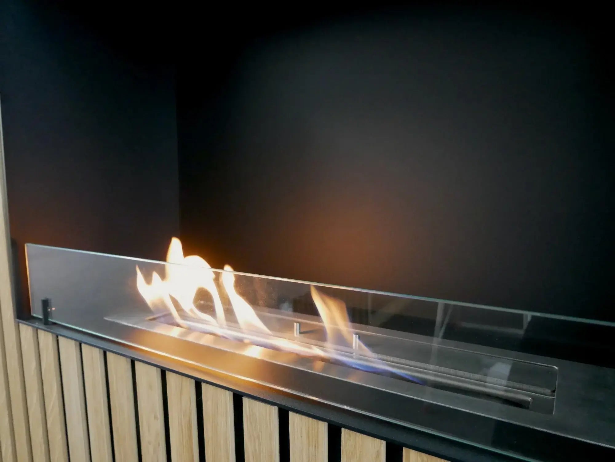 Modern bioethanol fireplace with flames visible through tempered glass in a stylish setting.
