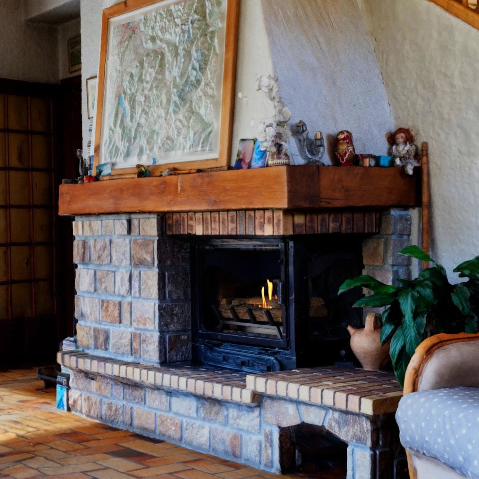 Cozy living room featuring a stone fireplace with a wooden mantel and decorative items, enhancing the warm atmosphere.