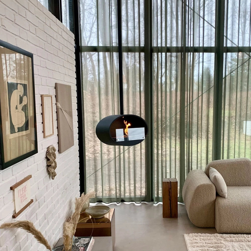 Hanging bioethanol fireplace in modern interior, showcasing flames in an elegant design near large windows.
