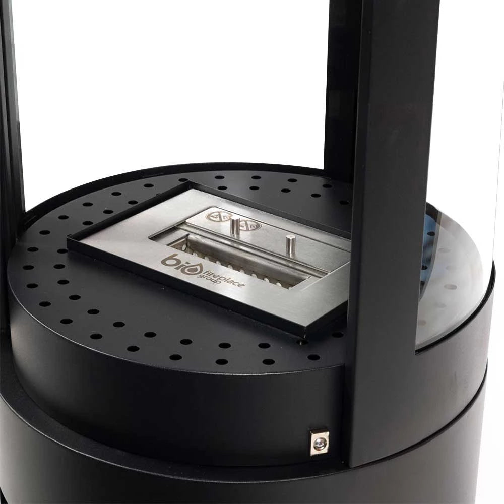 Close-up of Columbus bioethanol stove showing manual burner and rounded glass design for 360-view flames.
