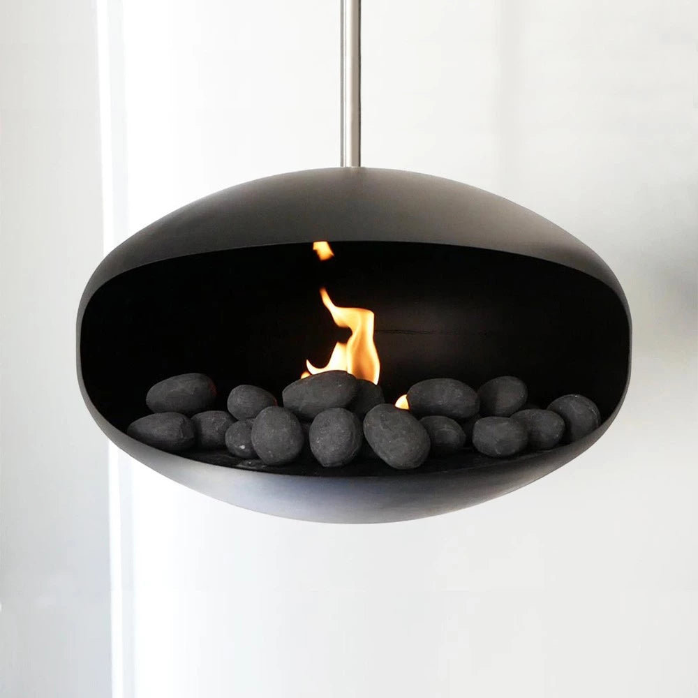 Modern bio fireplace with black decorative ceramic pebbles and flame, showcasing elegant design and ambiance.