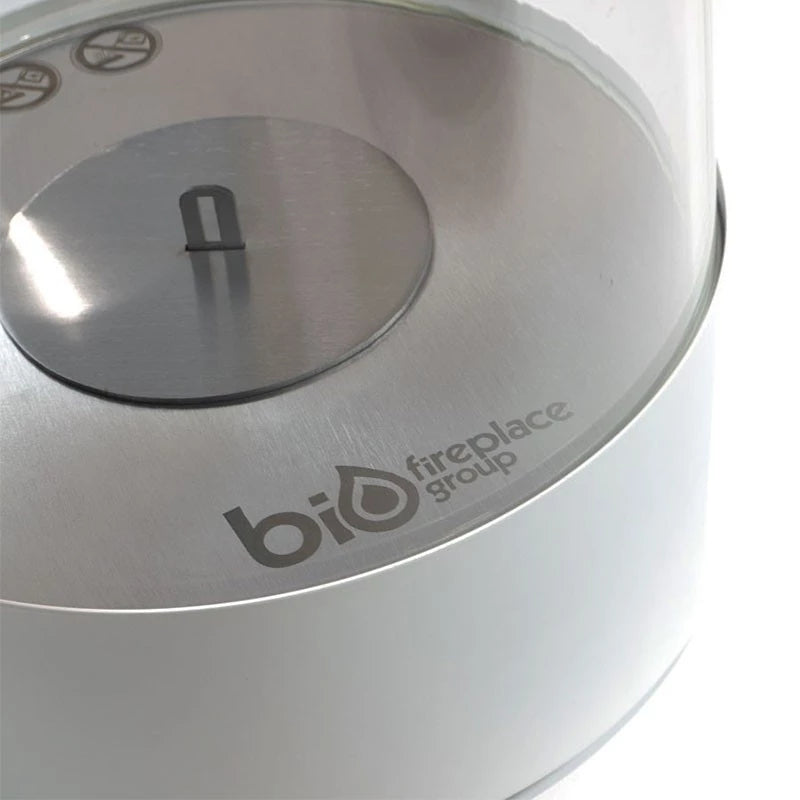 Close-up of Southwark White round tabletop bioethanol fireplace with stainless steel burner and glass enclosure.
