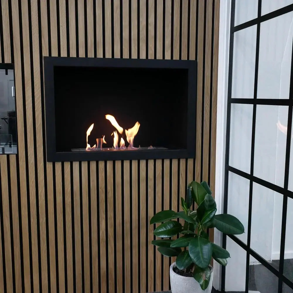 Stylish bioethanol fireplace insert built into a wooden wall, creating a cozy atmosphere with visible flames.