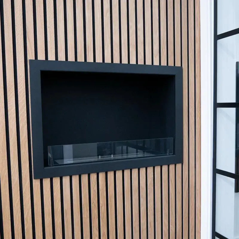 Stylish built-in bioethanol fireplace insert with tempered glass on a wood-paneled wall.