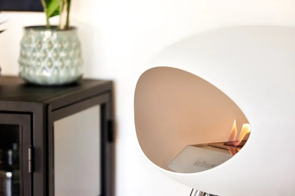 Modern bioethanol fireplace Le Feu Dome Ground Low in white, showcasing flames and stylish design in a cozy interior.
