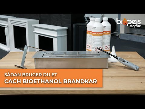 Cach bioethanol burner kit setup with fuel bottles and ignition tool on a wooden surface.