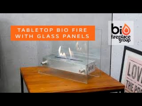 Tabletop bioethanol fireplace with glass panels, showcasing elegant flames and sleek design.