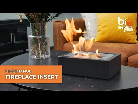 Bioethanol fireplace insert displayed on a table, showcasing vibrant flames and modern design.