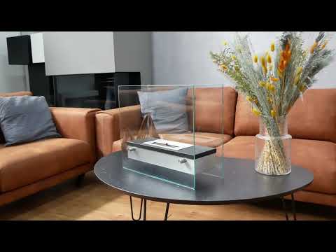 Merton Table Bio Fireplace on a coffee table, showcasing its elegant design with steel base and glass body.