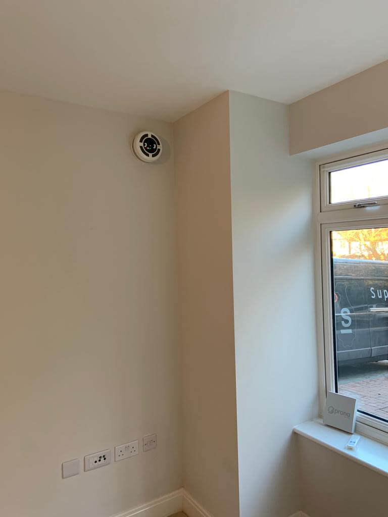 Heat recovery ventilator installed in the corner of a room, providing efficient ventilation and fresh air.