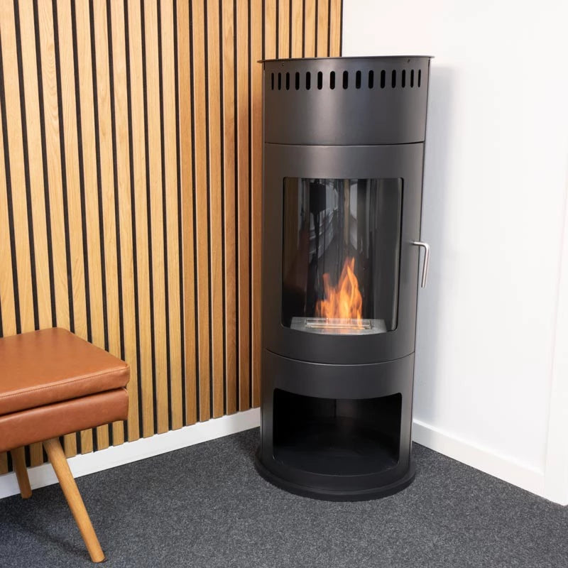 Washington Bioethanol Wood-burning Stove in stylish black design with glass front and flames, positioned in a modern living space.