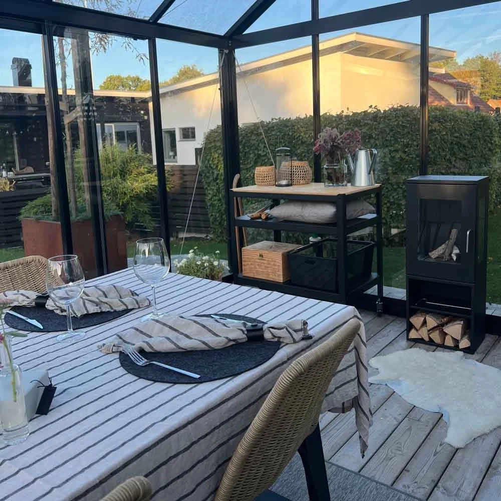 Elegant outdoor dining area featuring a freestanding bioethanol fireplace and a modern table setting.