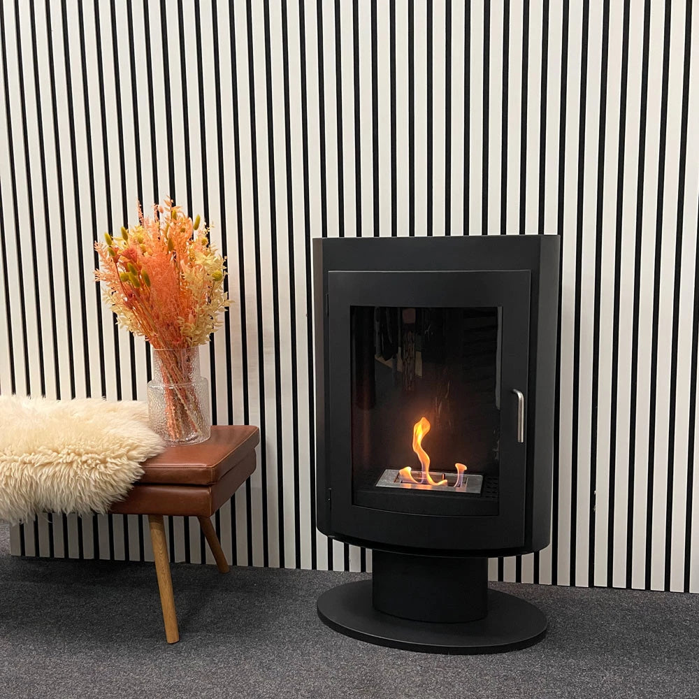Trenton freestanding bioethanol stove on stand with flames, surrounded by stylish decor and modern backdrop.