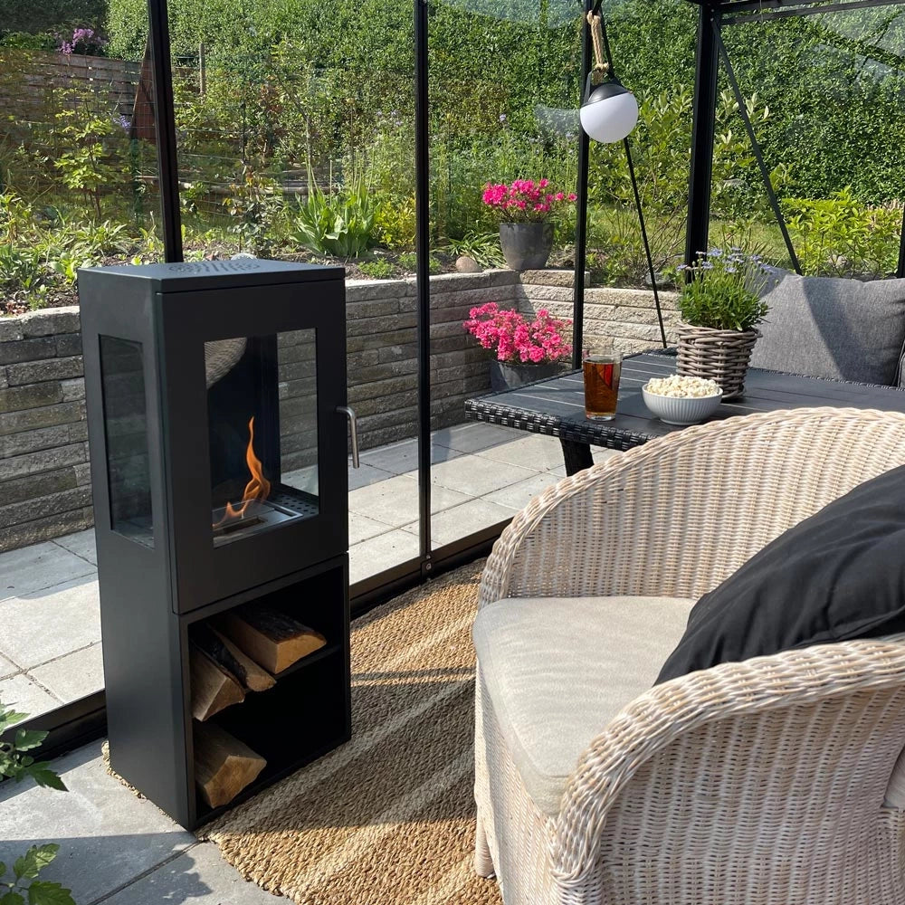 Cheyenne bioethanol fireplace in a modern outdoor setting with glass sides and flames visible.