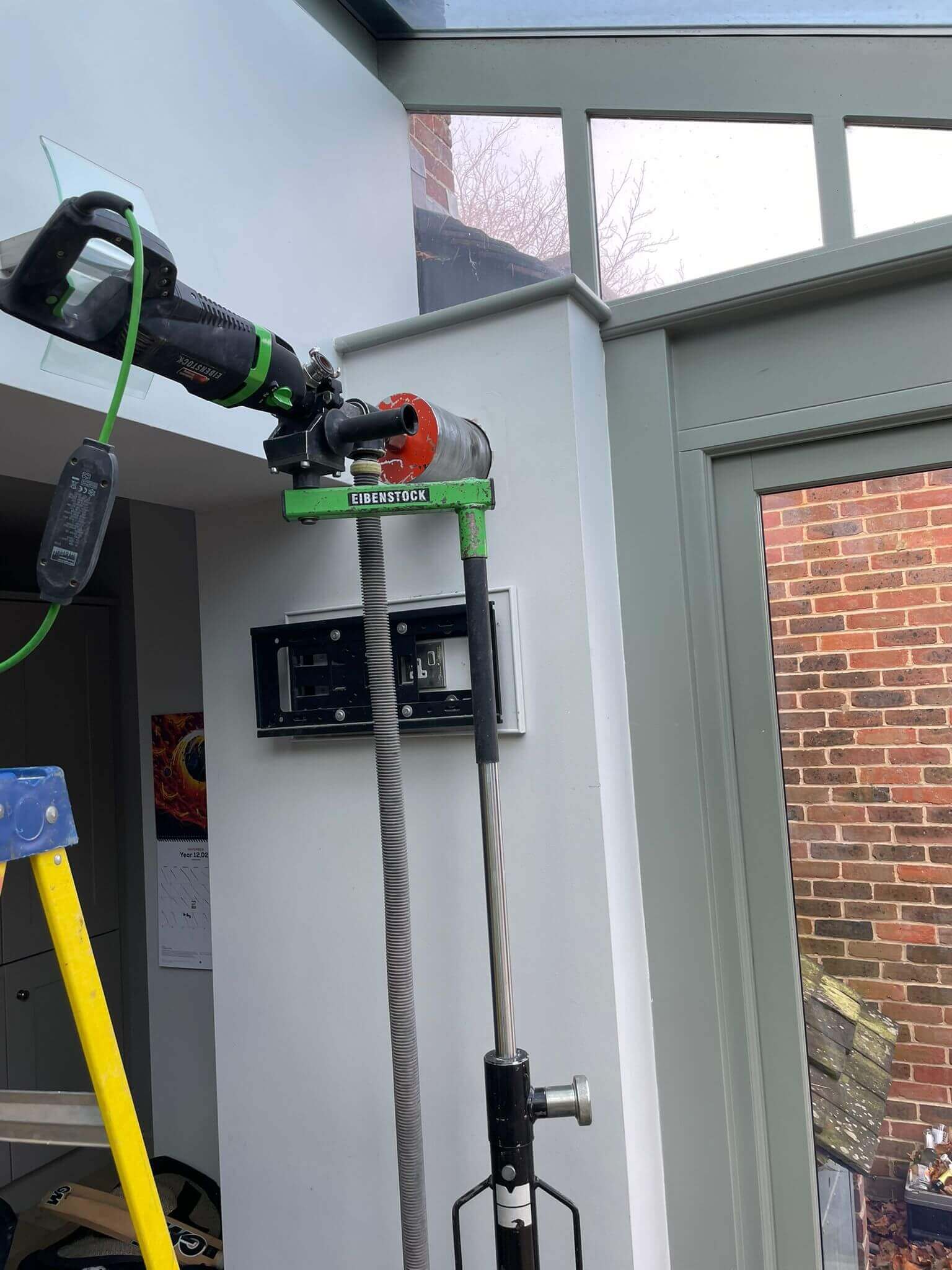 Installation of a heat recovery ventilation system using mechanical tools in a modern living space.