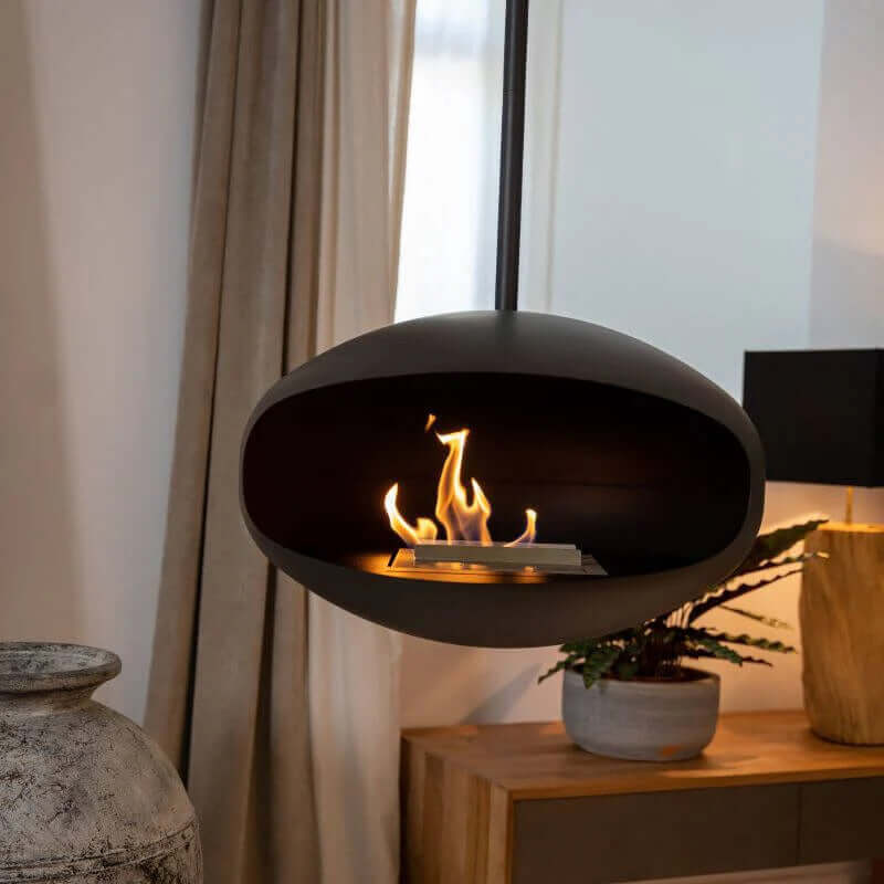 Cocoon Aeris matte black bioethanol fireplace, modern ceiling-mounted design creating a cozy atmosphere.
