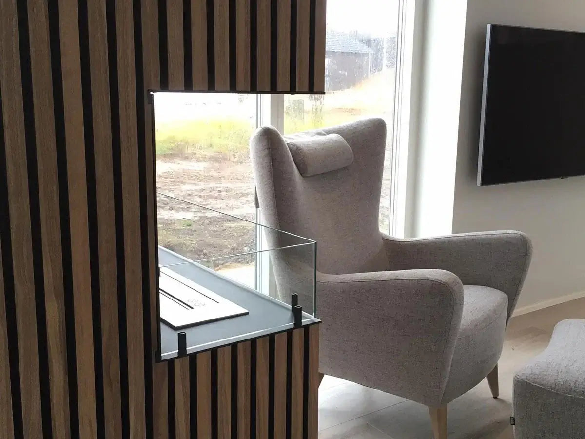 Contemporary living room featuring a stylish gray armchair and a modern wooden wall with a built-in glass shelf.
