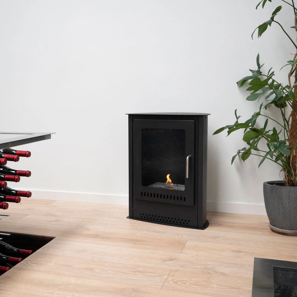 Small bioethanol fireplace in modern interior, freestanding design with visible flame and wine storage nearby.