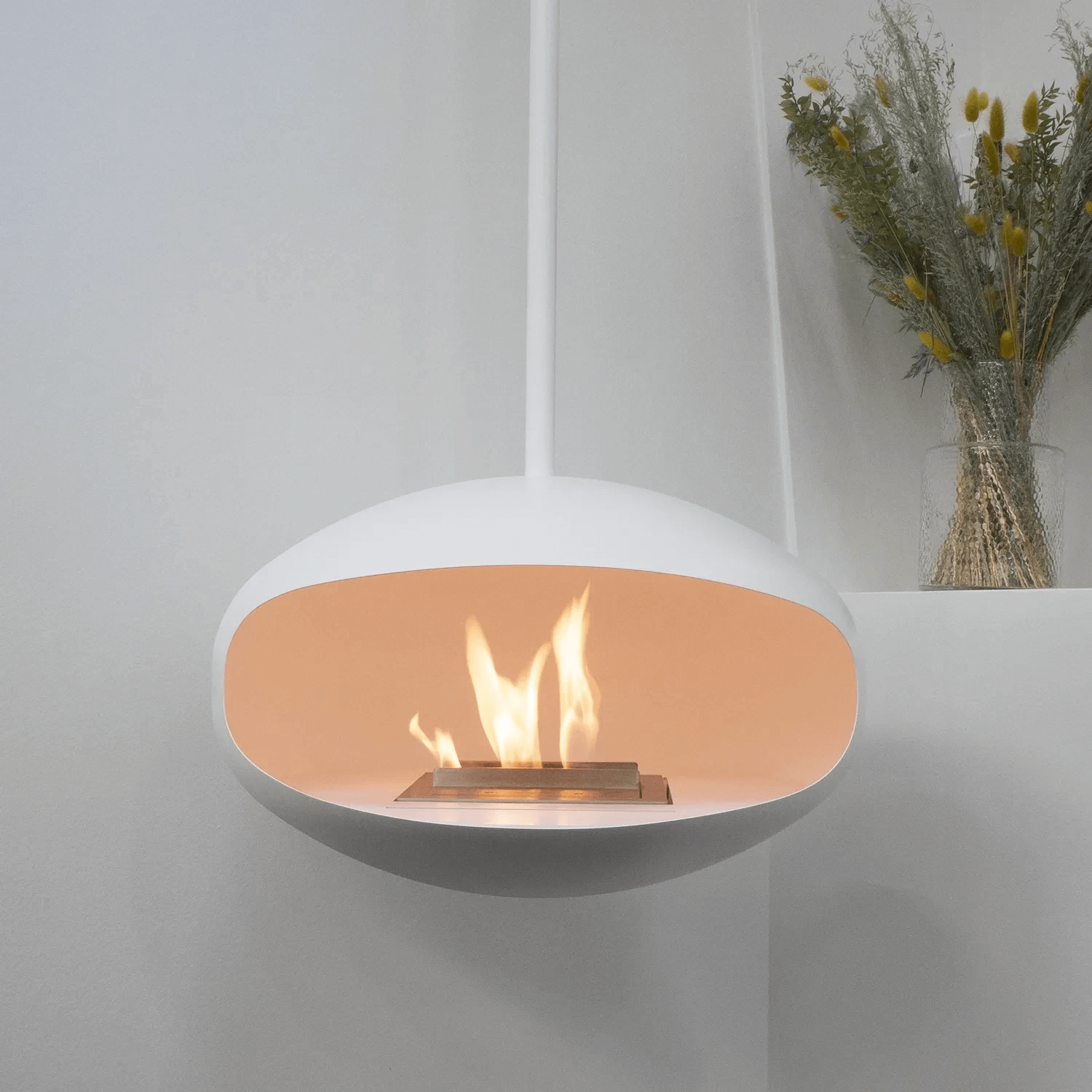 Cocoon Aeris ceiling-hung bioethanol fireplace in matte white with flames, designed for easy installation.