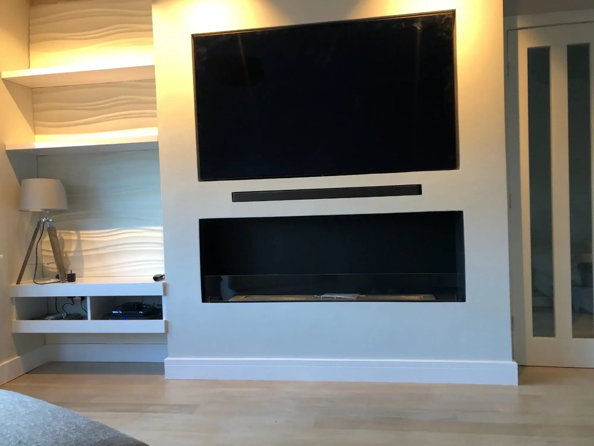 Modern living room with a sleek TV design and built-in bioethanol fireplace underneath, featuring stylish cabinetry.