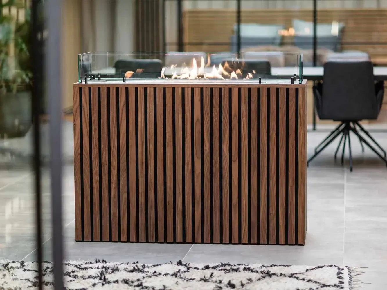 Modern bioethanol fireplace with glass surround, stylish wooden design, flames glowing in contemporary interior.